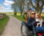 Carrie-Ann on an off-road wheelchair with her dog on her knee