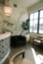 Elegant dental office interior with reception desk, chairs, and leafy mural background.