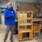 Jayminson stands in front of future bookshelf project that he sanded and prepped for painting