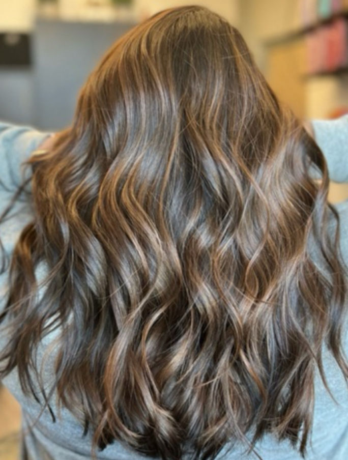 Close-up view of hair stylist applying color treatment to hair
