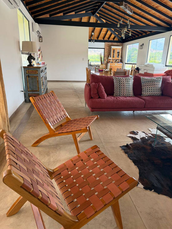 Cozy living room with woven chairs and red sofa.