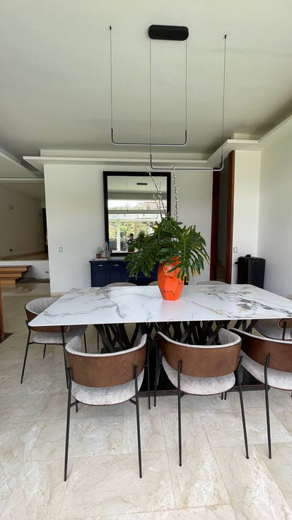 Dining room with marble table and orange vase.