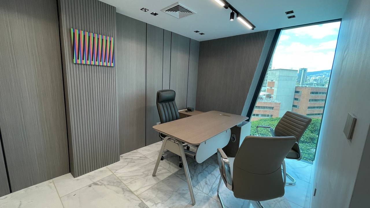 Modern office with desk, chairs, and large window.