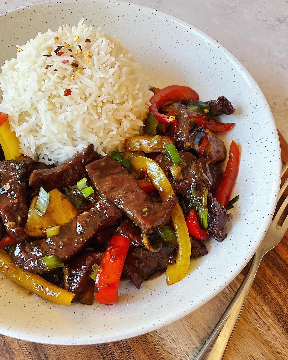 In bowl honey chilli beef with boiled rice.