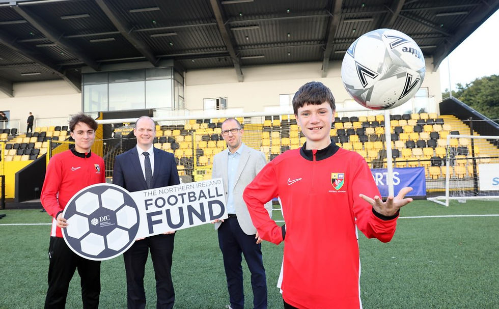 Communities Minister Gordon Lyons pictured at Blanchflower Stadium with Graham Fitzgerald, Chief Operating Officer at the Irish Football Association, and Jake and Leon from Ashfield Boys' High School.