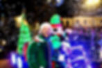 Festive characters entertaining the crowds with a car blowing bubbles.
