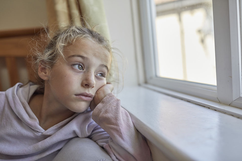 Young girl looking out window