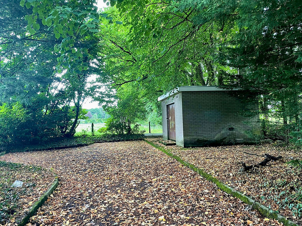 Small brick building in wooded area