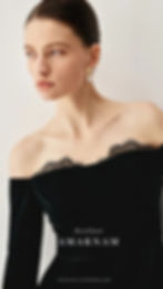 Woman in black off-shoulder dress with lace, gold earrings, looking sideways. Text: Atelier AMARNAM, AMARNAM-ACCESSORIES.COM.