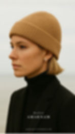 Person in a tan beanie and black turtleneck gazes outward, wearing an earring. Text: Atelier AMARNAM. Mood is calm and introspective.