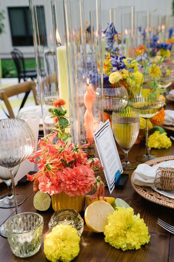 yellow and orange wedding flowers with fruit on table
