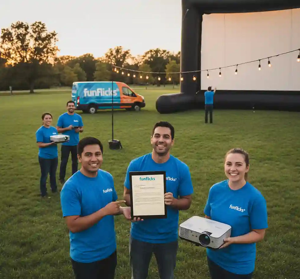 A group of smiling event technicians in "funflicks" branded shirts stand in a grassy field with a large inflatable screen setup in the background. One technician holds a tablet displaying a document, another holds a projector, and a funflicks van is visible in the distance.