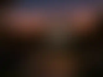 Family enjoying a backyard movie night with an outdoor screen, cozy seating, and string lights under the stars