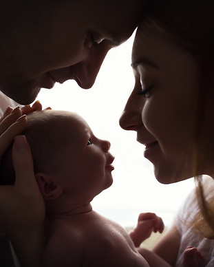 Happy family with newborn baby by the window.jpg