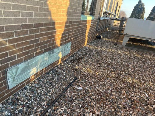 Photo of needed site work on the exterior of a school building