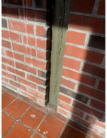 Photo of worn brick and flooring in the A-Wing of the high school.