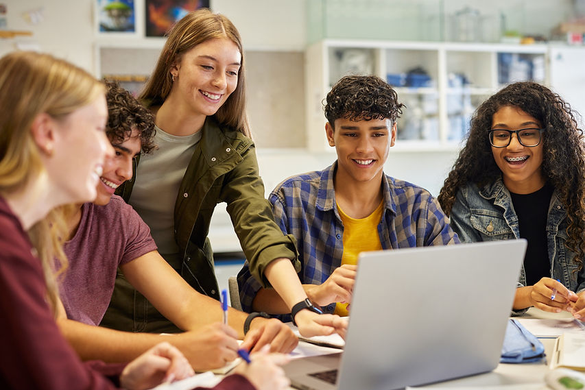 Multiethnic casual students using laptop during research, working together on a project Di