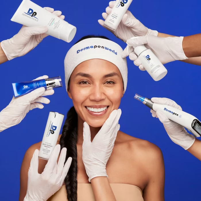 Smiling woman with Face Reality headband, surrounded by skincare products