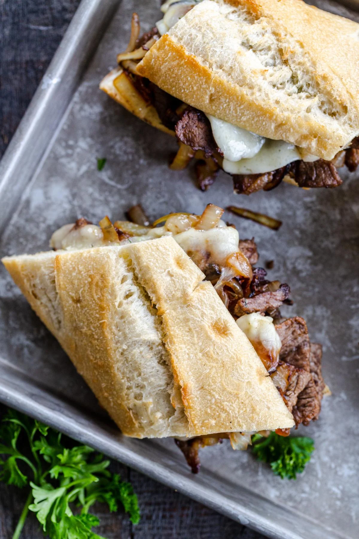 Philly cheesesteak halves with caramelized onions and cheese, catered by Always Fresh BBQ Catering for private events, corporate gatherings, and birthday BBQs.
