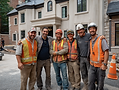 u9973394322_masonry_team_smiling_with_newly_built_mansion_in_th_ea44d8a7-9576-46c6-8990-fb