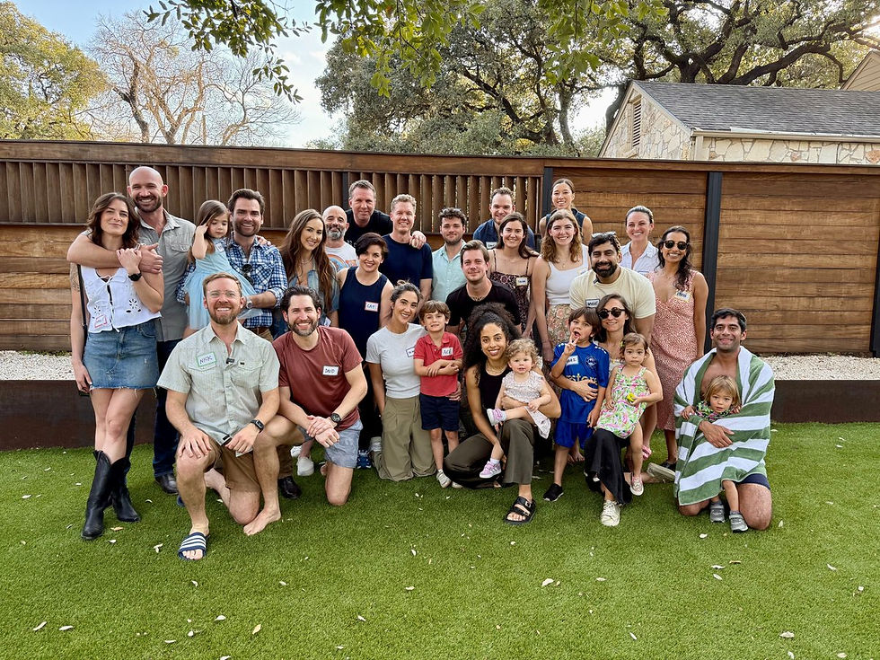 Family members smiling and gathering for a group photo at an outdoor BBQ catering party