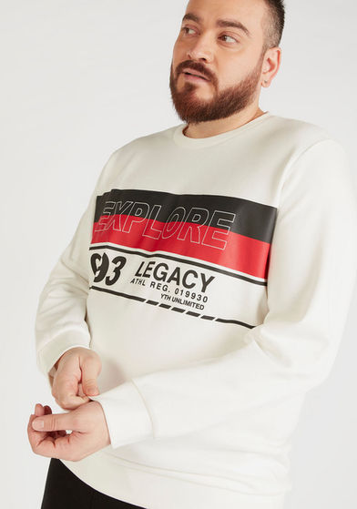 Hadi wearing a white sweatshirt, holding his wrist