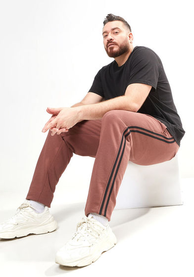 Hadi sitting with a black shirt and maroon pants