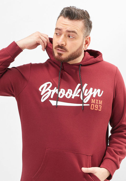 Hadi wearing a maroon hoodie, holding the collar