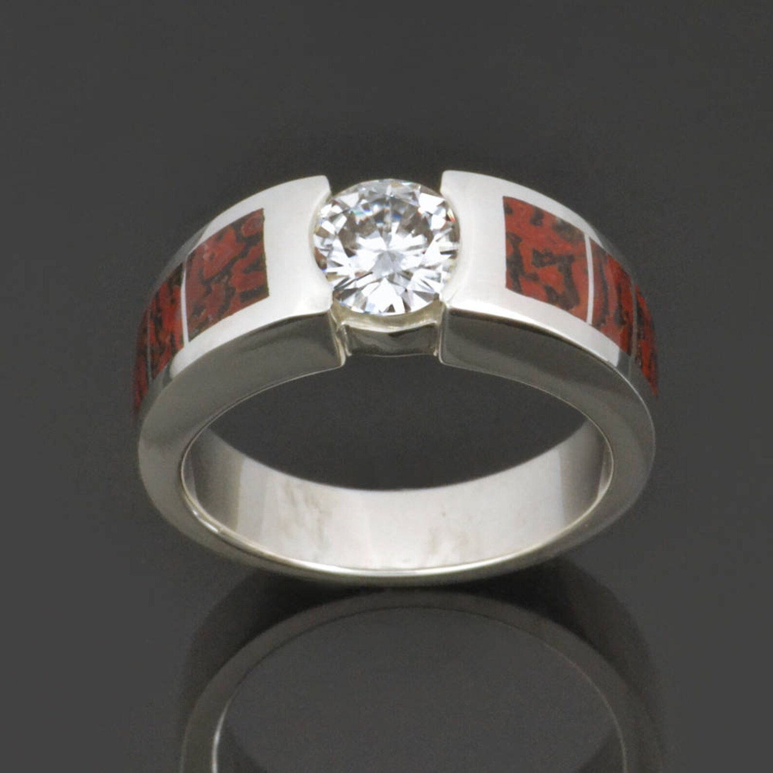 Red dinosaur bone engagement ring with moissanite by Hileman.