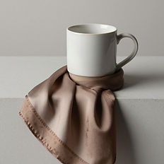 A coffee mug with a blanket on a stool