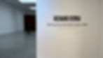 Gallery wall displays "Richard Serra: Running Arcs (For John Cage), 1992" with dates. Dimly lit gallery, person in dark suit stands nearby. Gagosian Gallery, New York, Richard Serra 'Running Arcs (For John Cage)', 1992