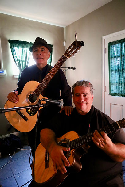 Members of Trio Los Angeles during a rehearsal, guitars in hand, seated by a window with soft daylight in the room