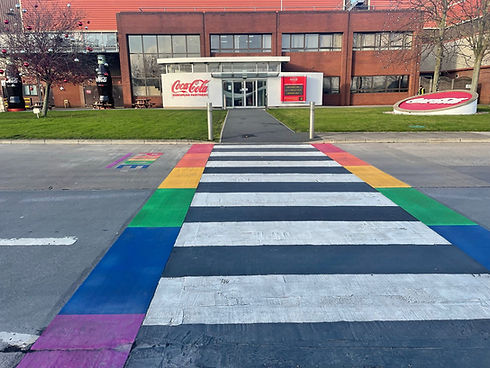 Rainbow-coloured zebra crossing outside Coca-Cola building