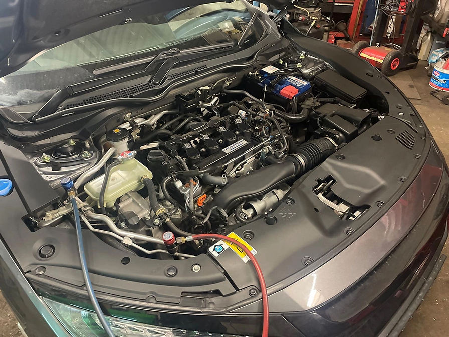 Car during service with bonnet lifted and engine exposed