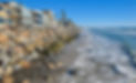 Oceanside beach with rocks and beach front homes.jpeg