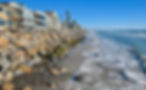 Oceanside beach with rocks and beach front homes.jpeg
