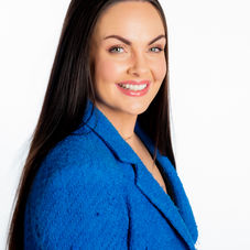Corporate headshot — three-quarter portrait in blue blazer, light background