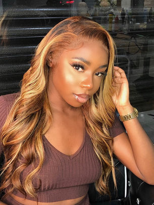 Black girl in a highlighted wig with a side parting and curls