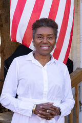 Winsome Earle-Sears smiling in front of an American flag at the Culpeper Life & Marriage Tour stop in Virginia.