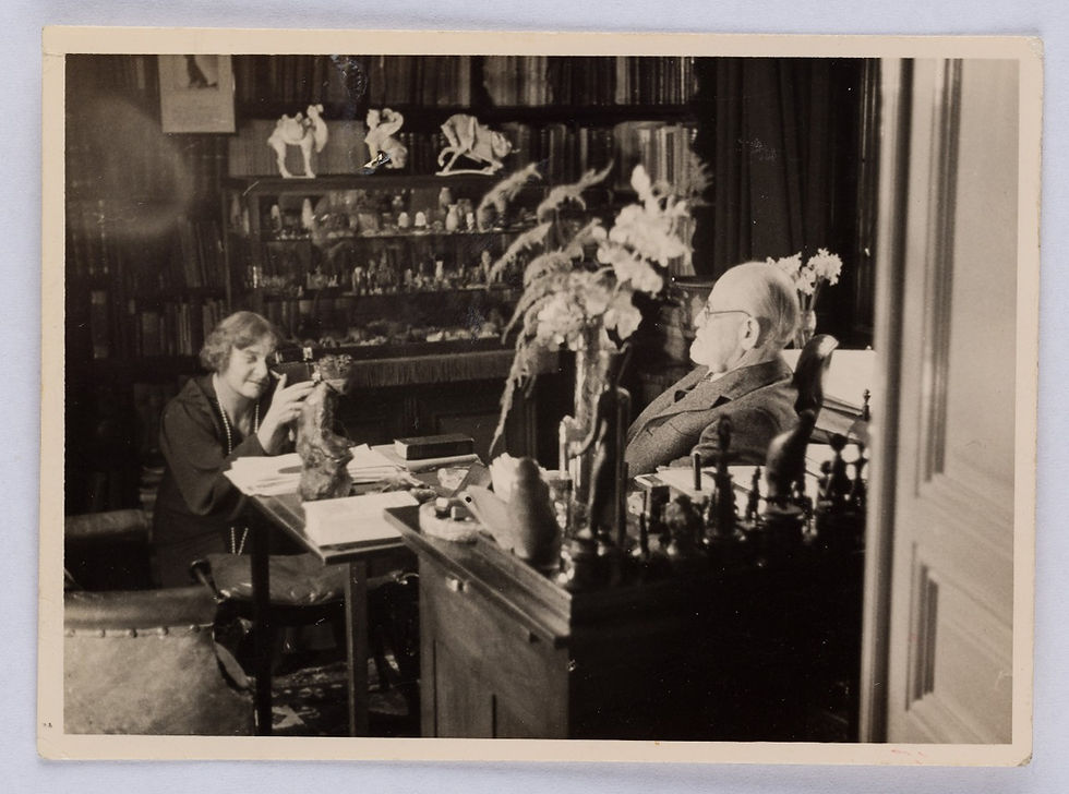 Black and white photograph showing a man and woman in study surrounded by ornaments