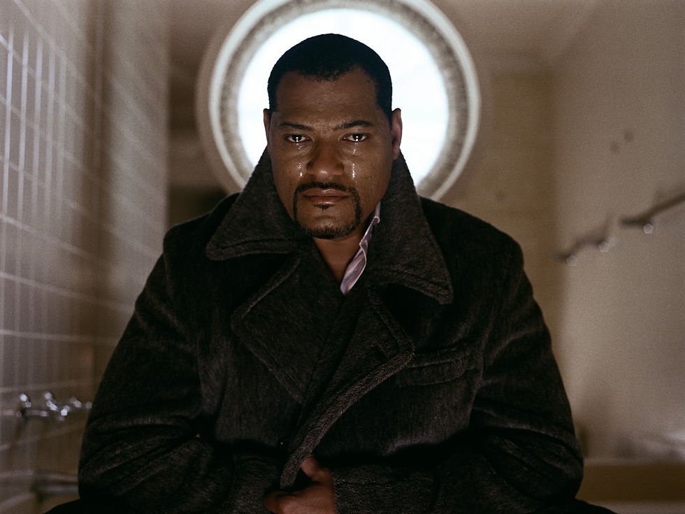 Lawrence Fishburne with tears in his eyes looking directly at the camera