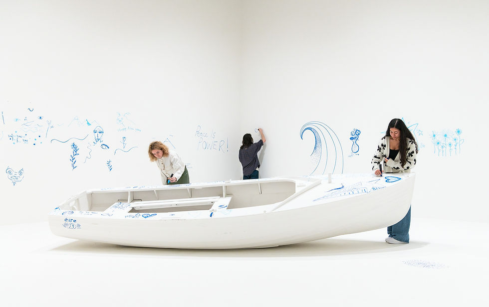 Visitors use pens to draw on a fully white boat and white walls