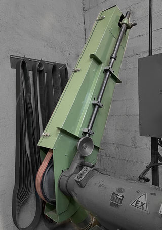 Carter de protection autour de la bande abrasive d'un touret de meulage