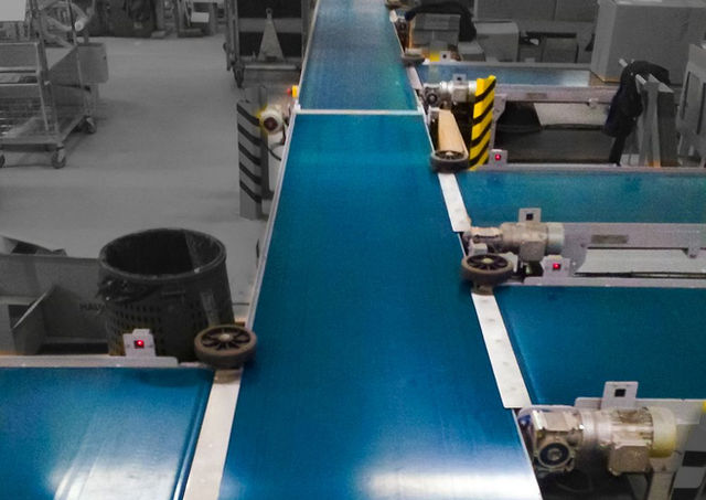 Ensemble de convoyeurs à bande légère et de postes de travail destinés à gérer le flux logistique