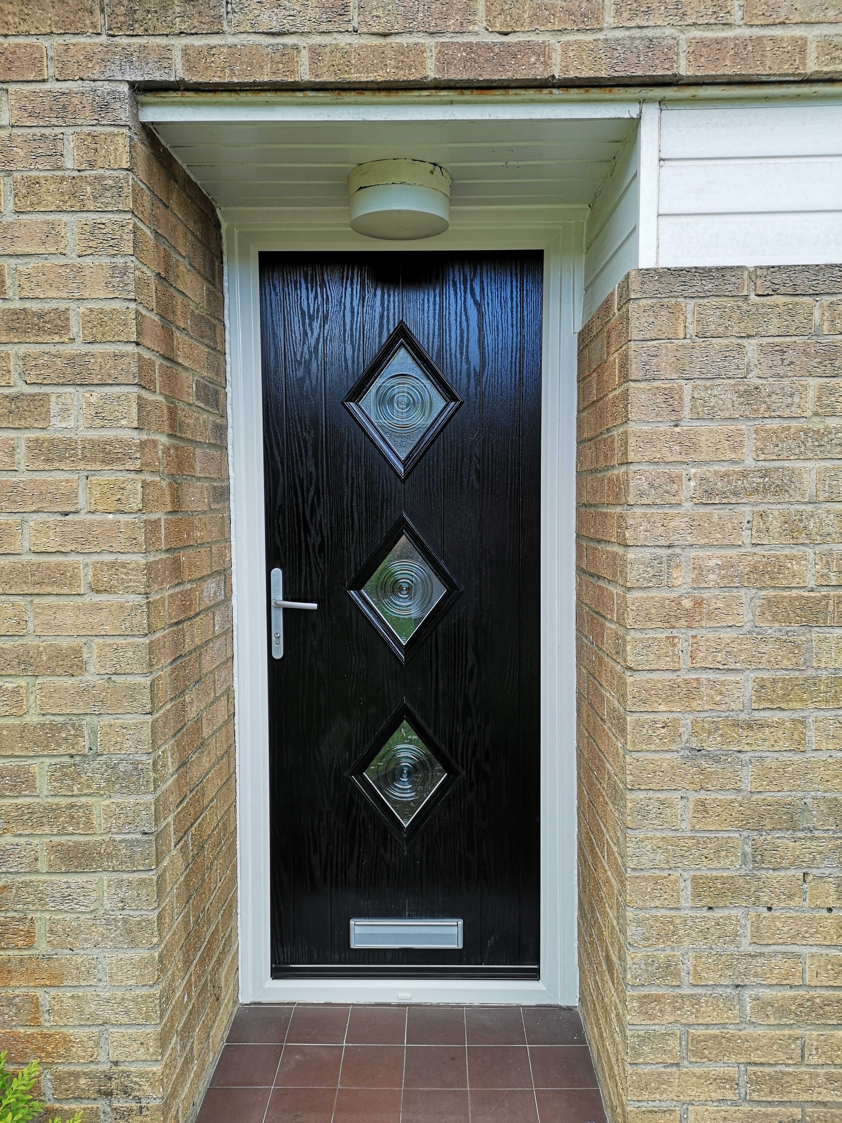 Cottage 3 Diamond Composite Door with bullseye glass, gloss black with chrome furniture.