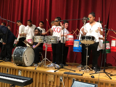 Drumline and Band students on stage