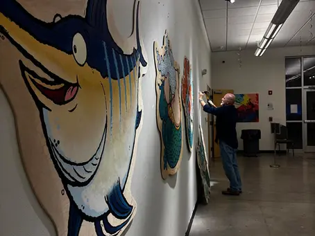 Artist Bob Ostrom setting up art at the the Dreams Center art gallery