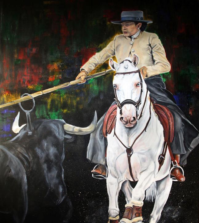 Female rider on a white horse secures a hoop from the bull obstacle