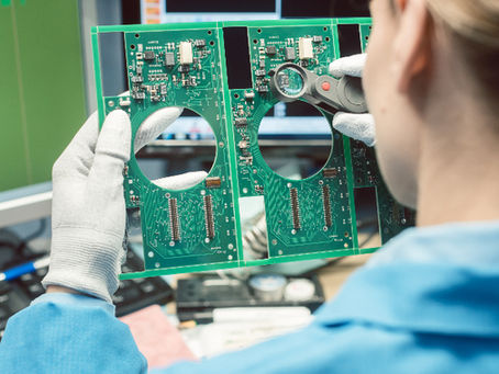 A women inspects electronics board visually.