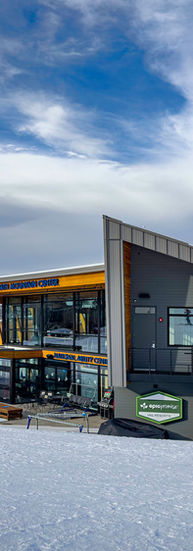 People play in the snow outside of the building.